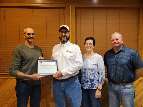 Coles County SWCD Board Chairman Bill Janes (left), Presents Wesley and Jane Orman (center) the award for 2021 Conservation Farmer of the Year. Coles County SWCD Board Member Pat Harrington is pictured at right.